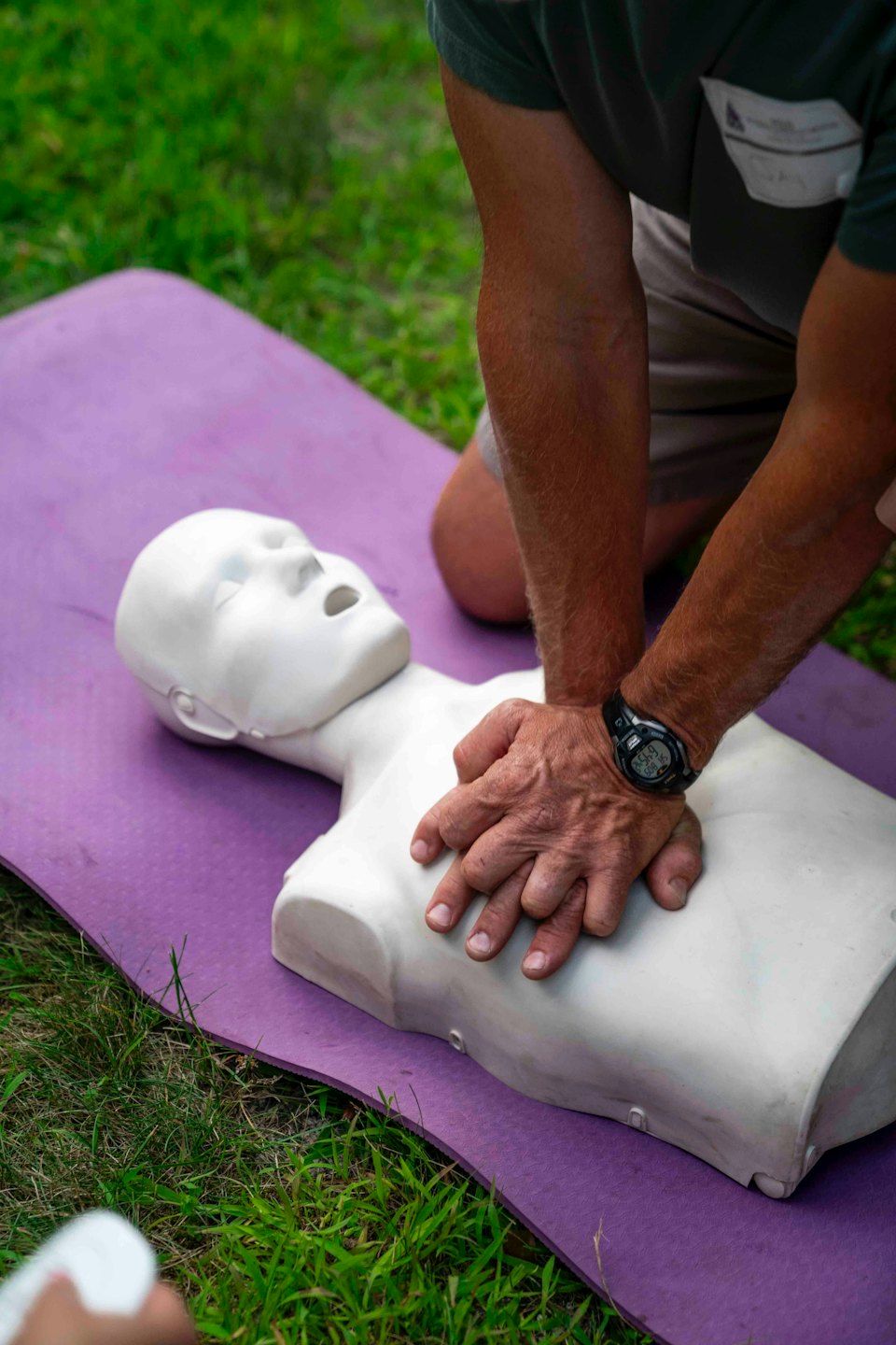 Persona che esegue compressioni toraciche su un manichino per la rianimazione cardiopolmonare.
